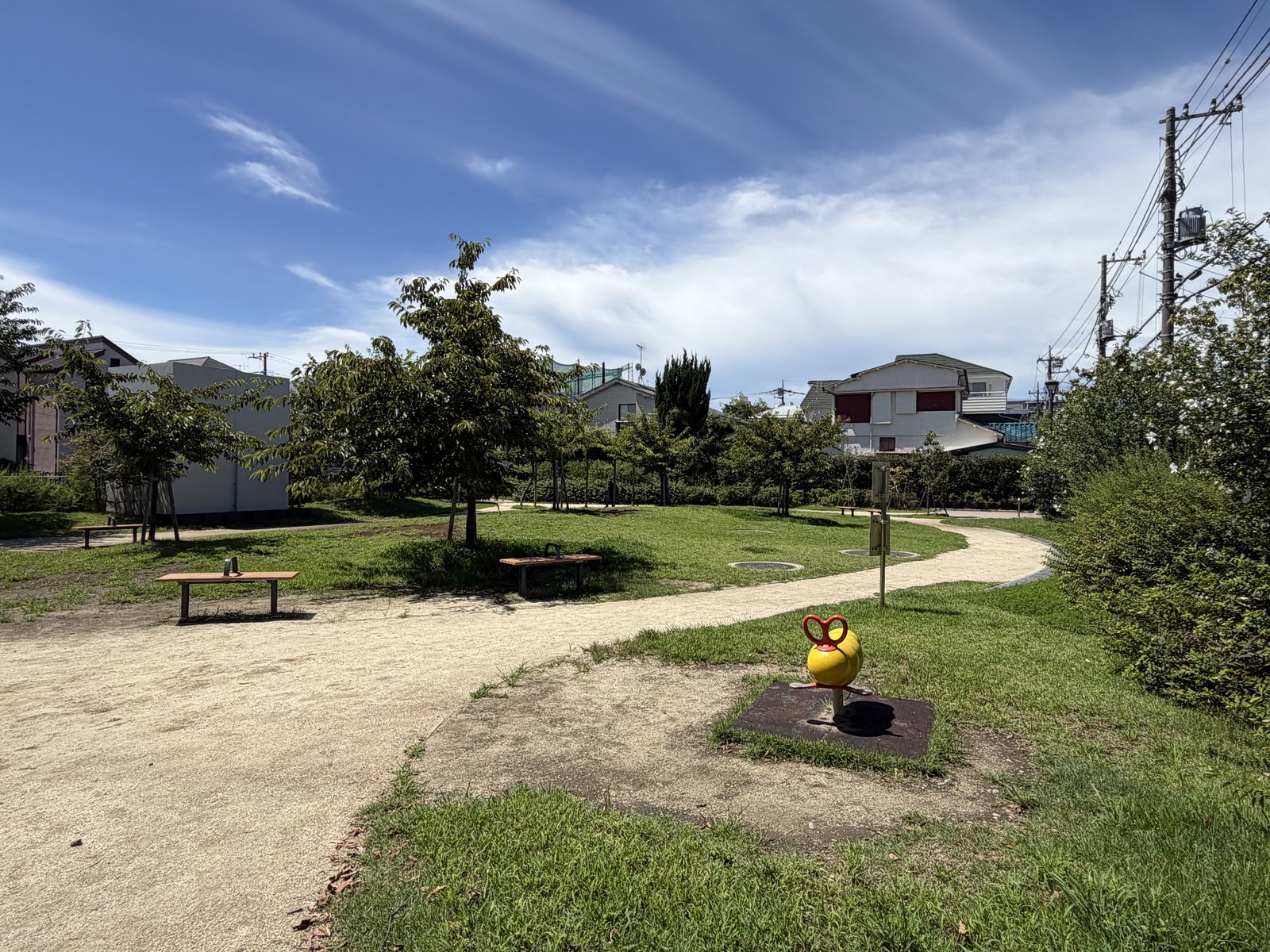 黄色のスプリング遊具と芝生広場